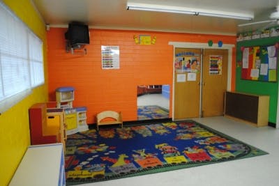 Playroom with colorful walls, a patterned rug, and small furniture