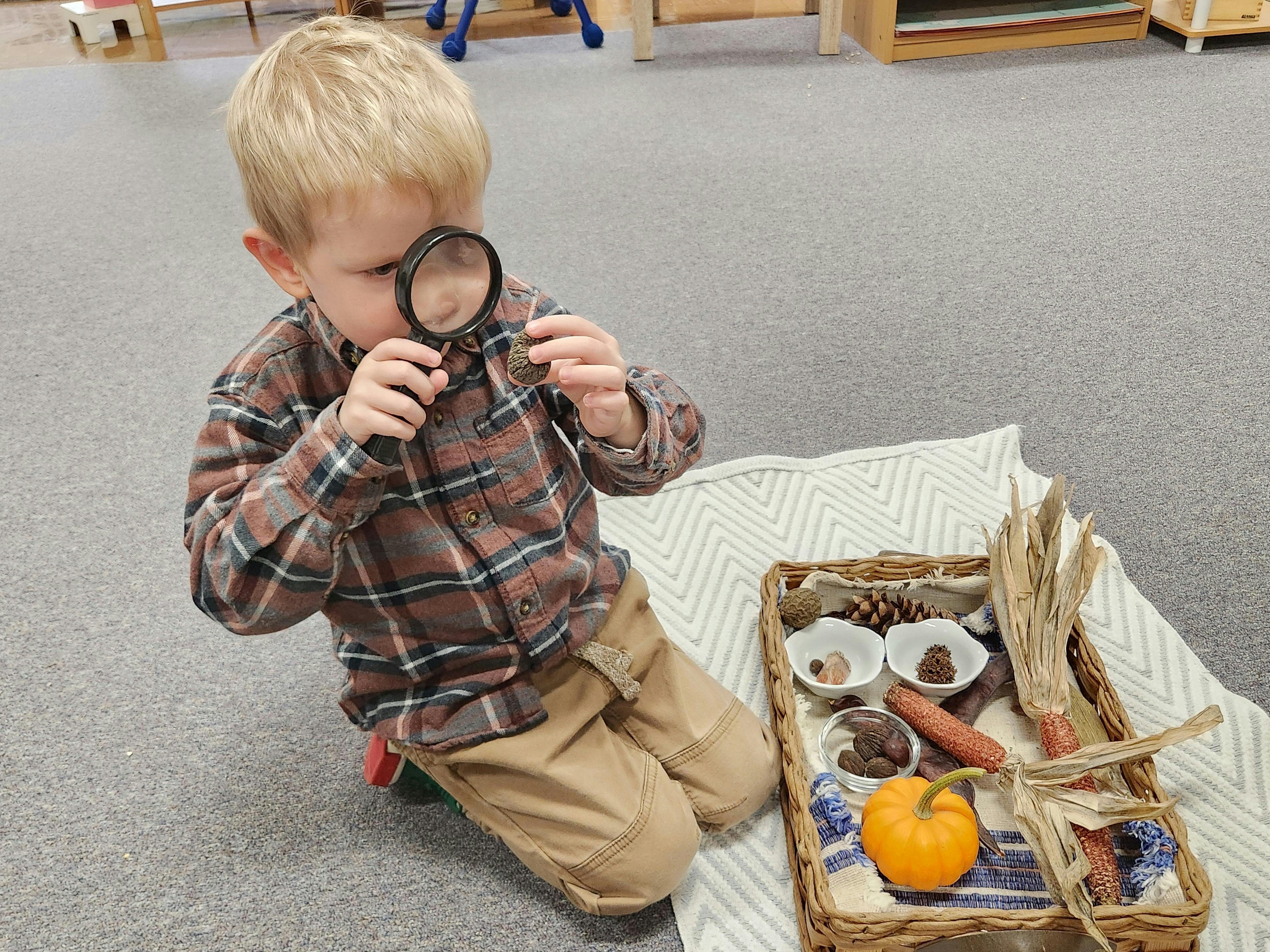 Child using a magnifying glass to examine a small object