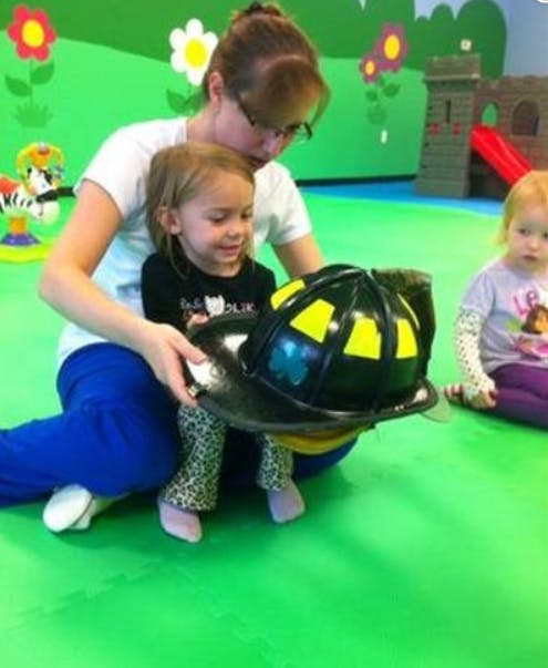 Person and child holding a firefighter helmet
