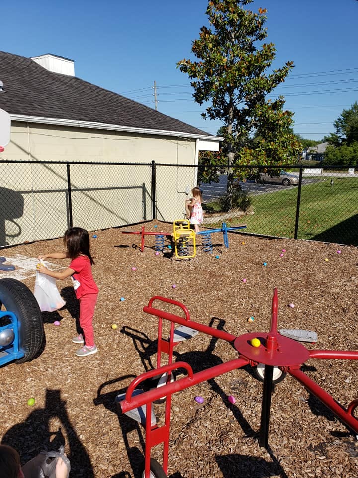 Child collecting eggs in a bag on a playground