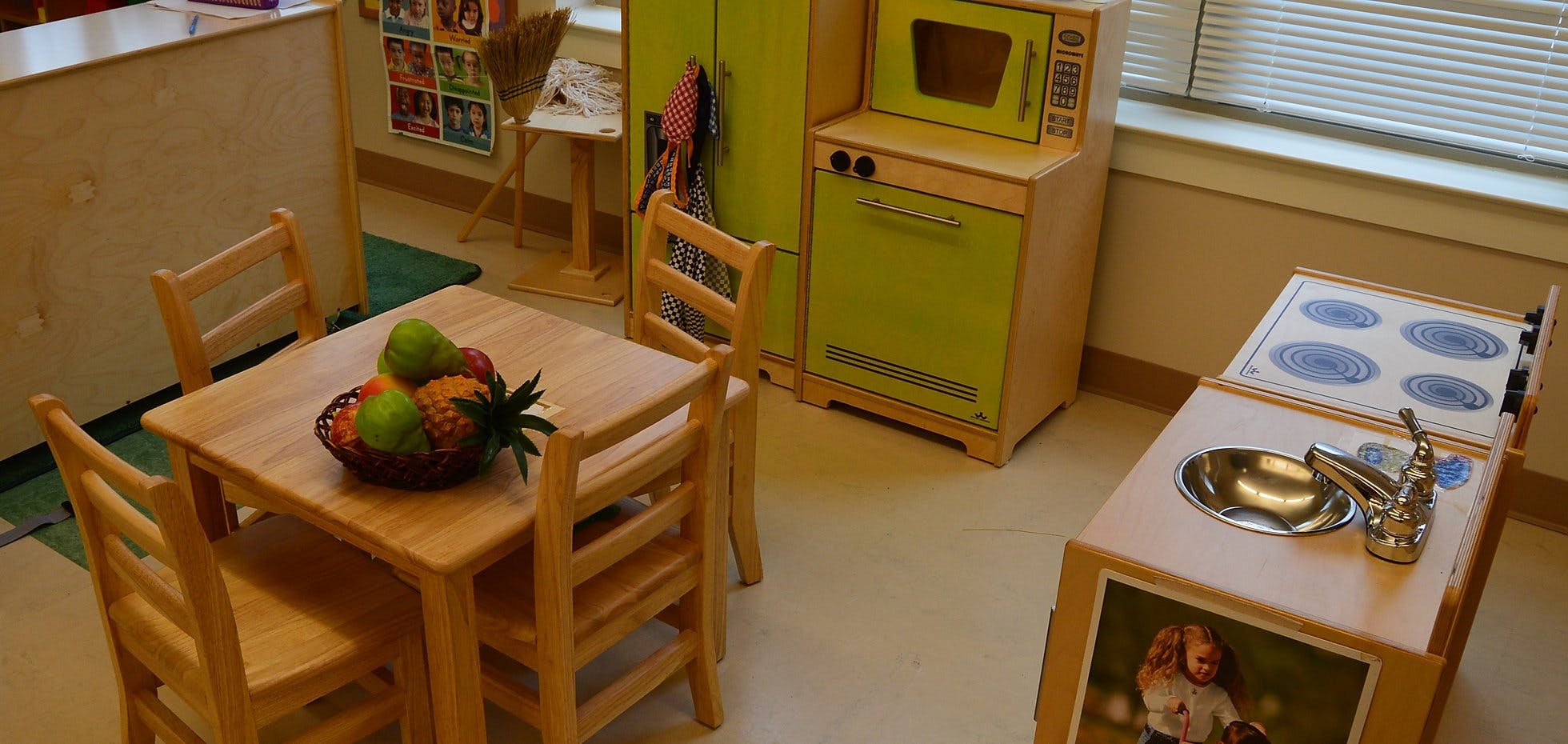 Play kitchen and small table with fruit in a classroom