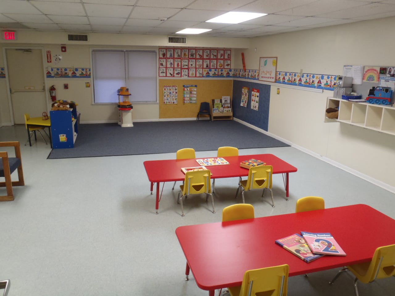 Empty classroom with red tables and yellow chairs