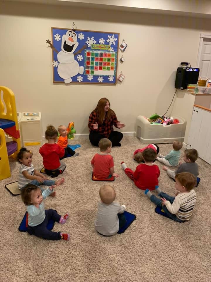 Adult leading a group of children in a classroom