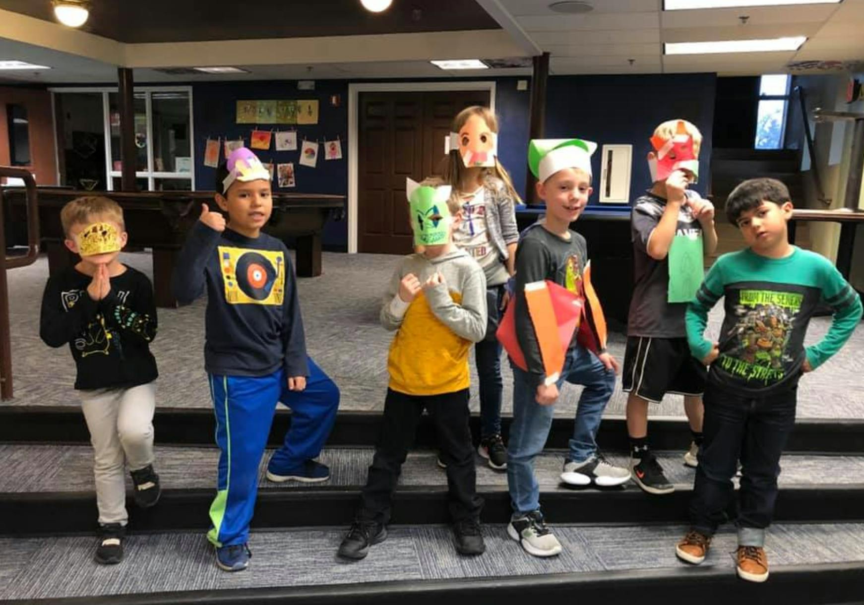 Group of children wearing masks and standing on steps