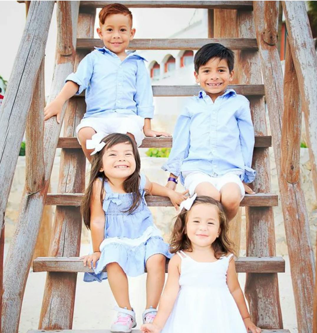 Four children sitting on wooden steps