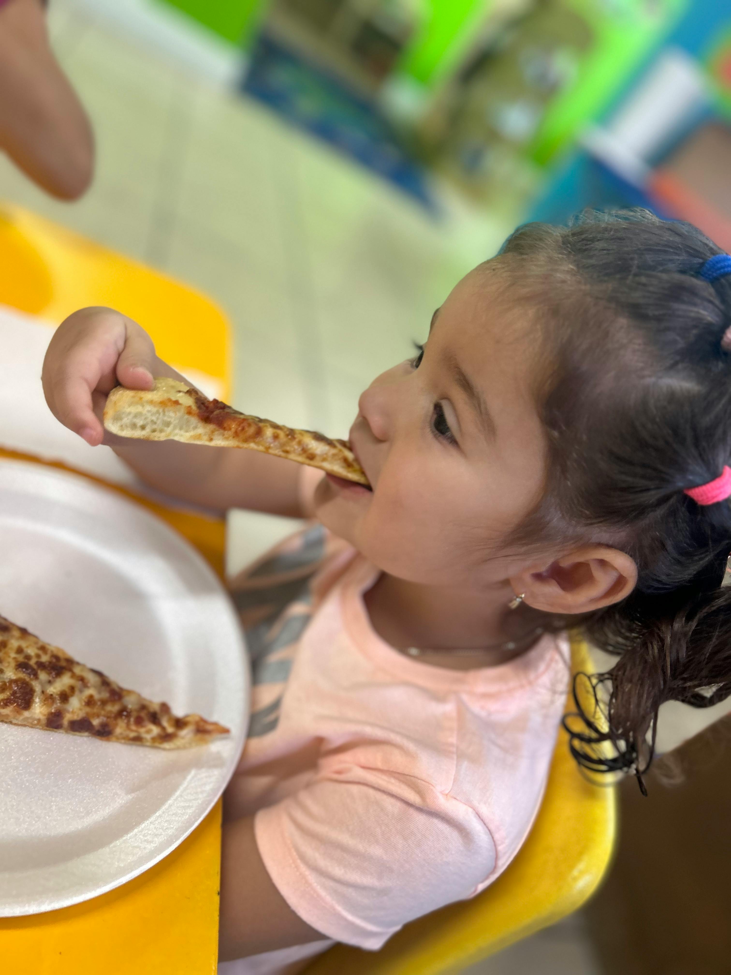 Child eating a slice of pizza