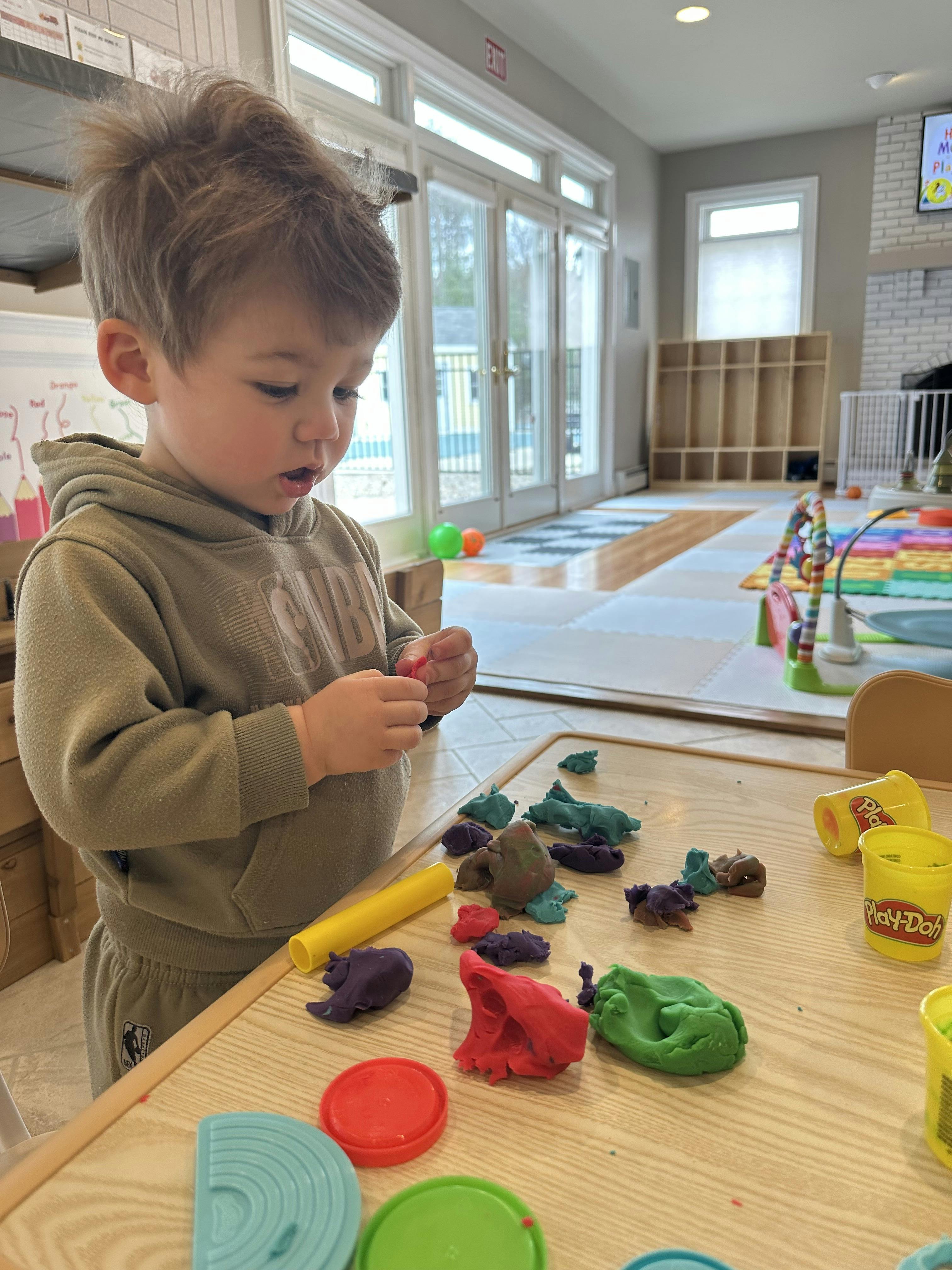 Child playing with Play-Doh at a table