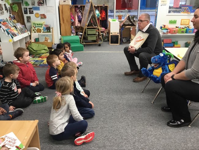 Adults reading to children in a classroom