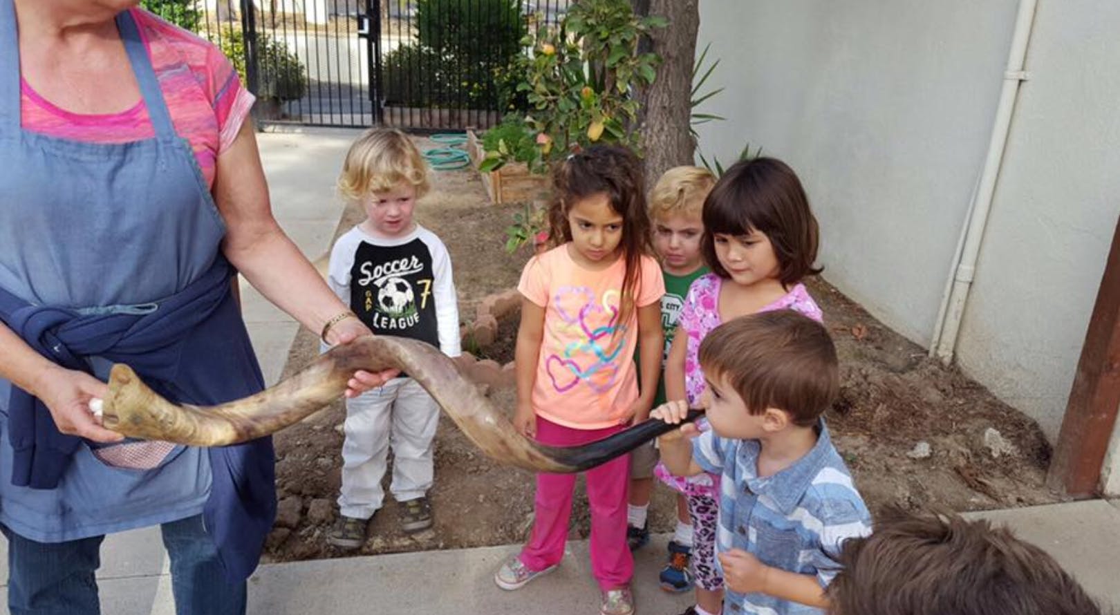Person holding a long object with children looking on