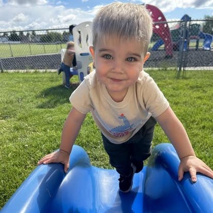 Child on a blue slide on a playground