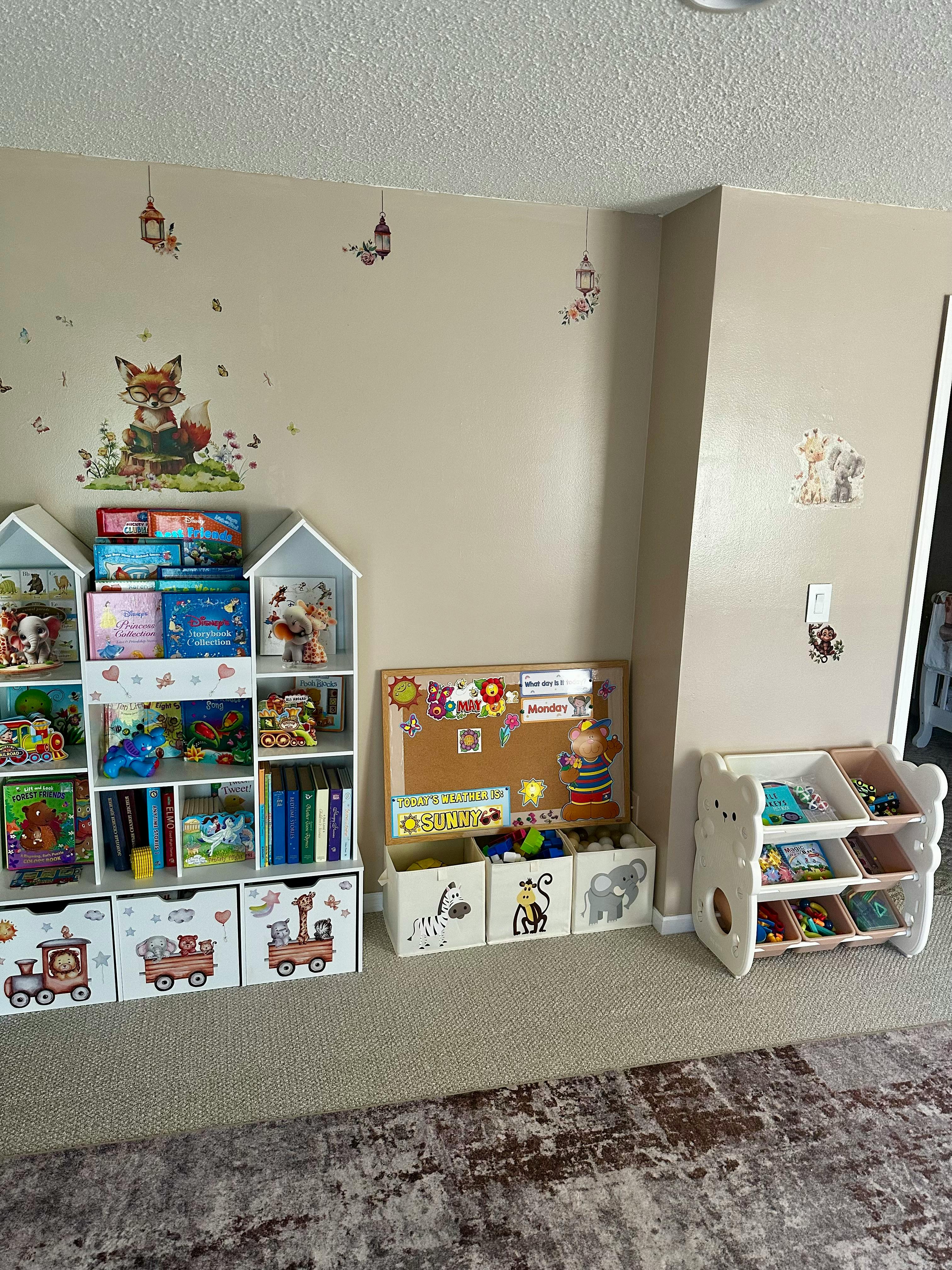 Children's room with bookshelves, toy storage, and wall decals