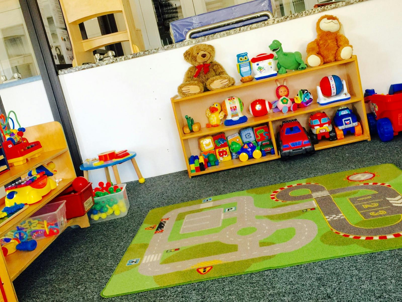 Playroom with toy shelves and a road map rug