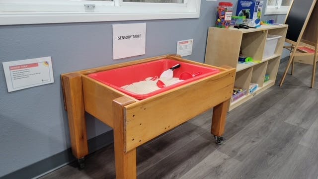 Sensory table with white material and scoop in a classroom