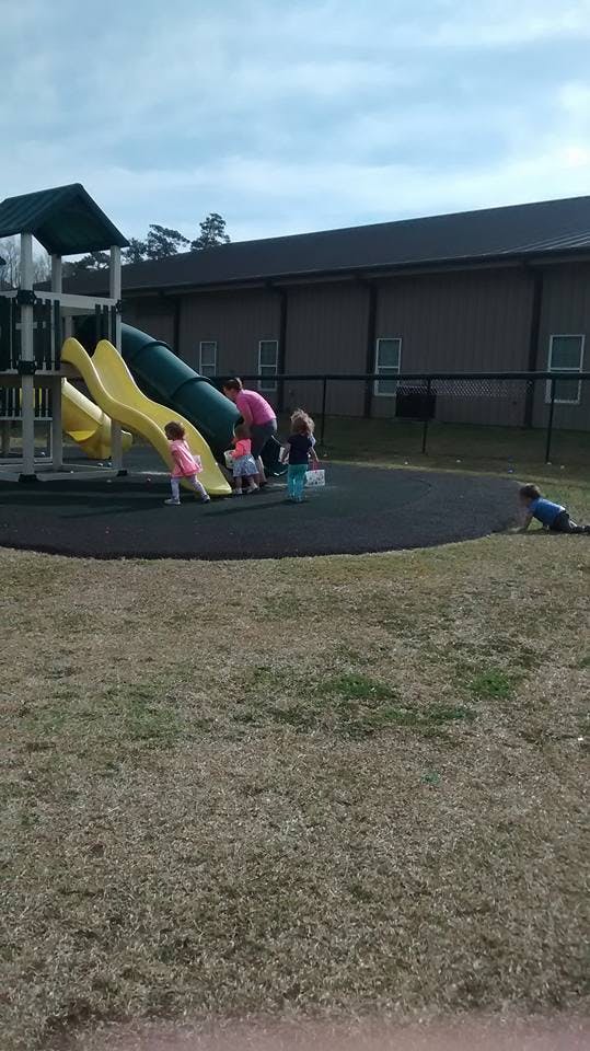 Children and an adult on a playground with slides