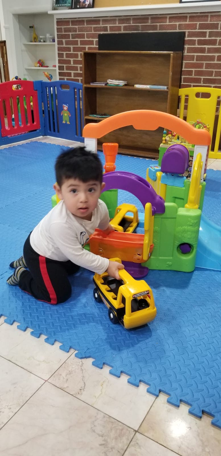 Child playing with a toy truck and play structure