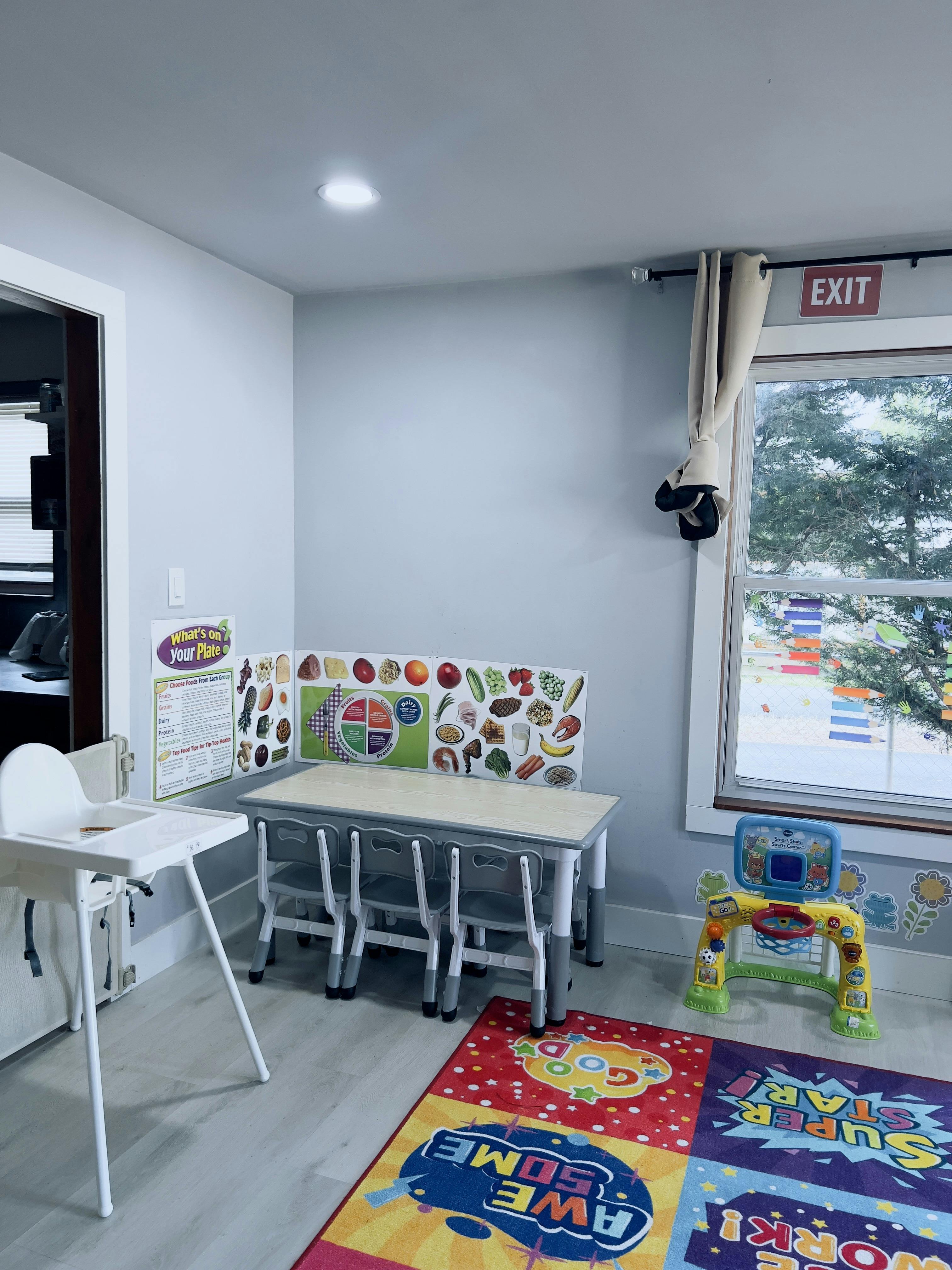 Child-sized table and chairs with nutrition poster in a play area