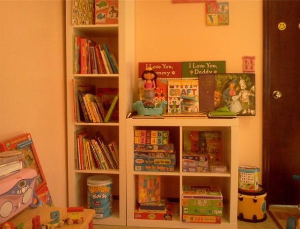 Bookshelves and cubby storage filled with books, games, and toys