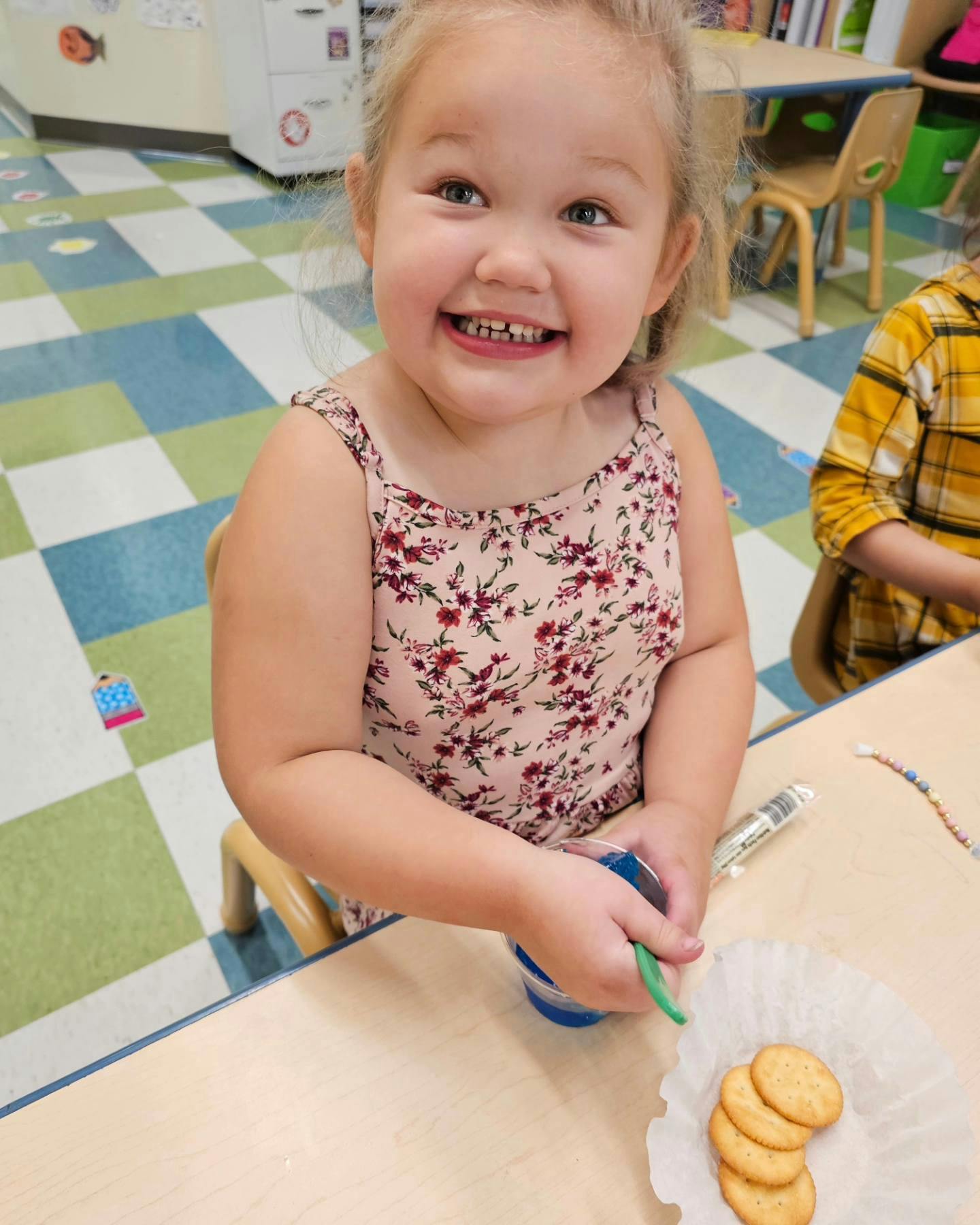 Child at a table with cookies and a cup