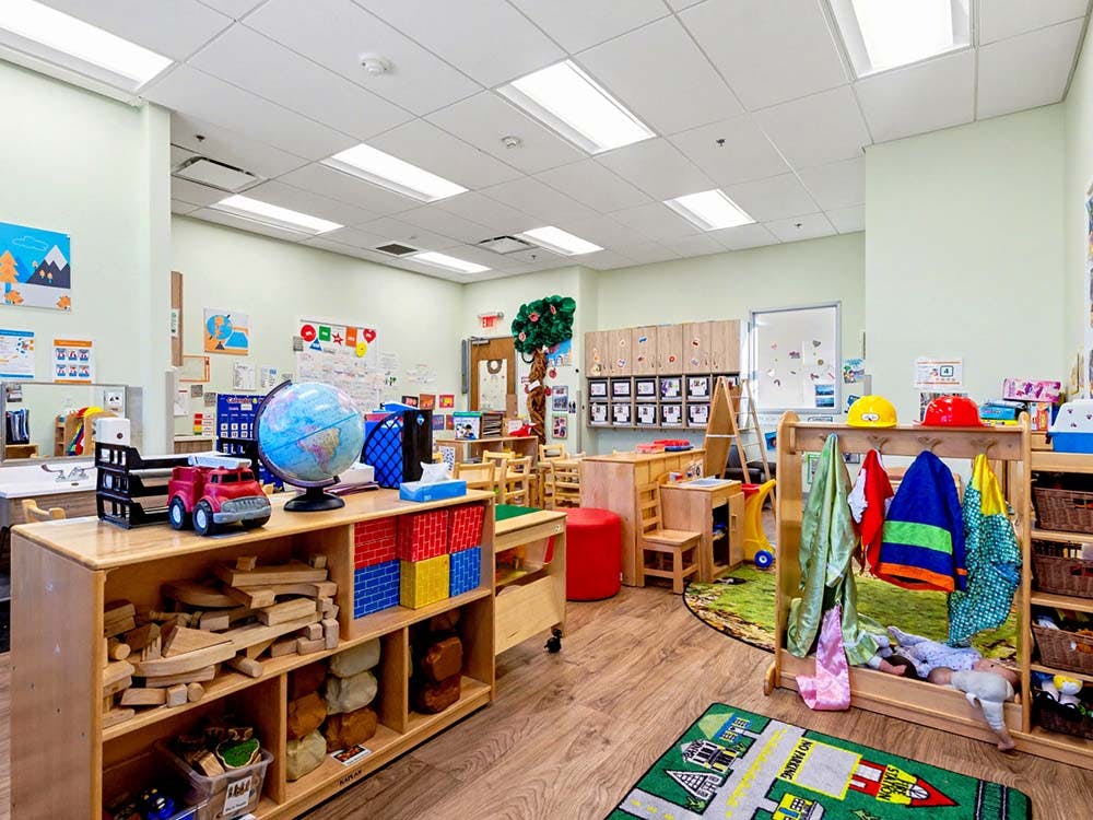 A colorful preschool classroom with toys, wooden blocks, and small tables
