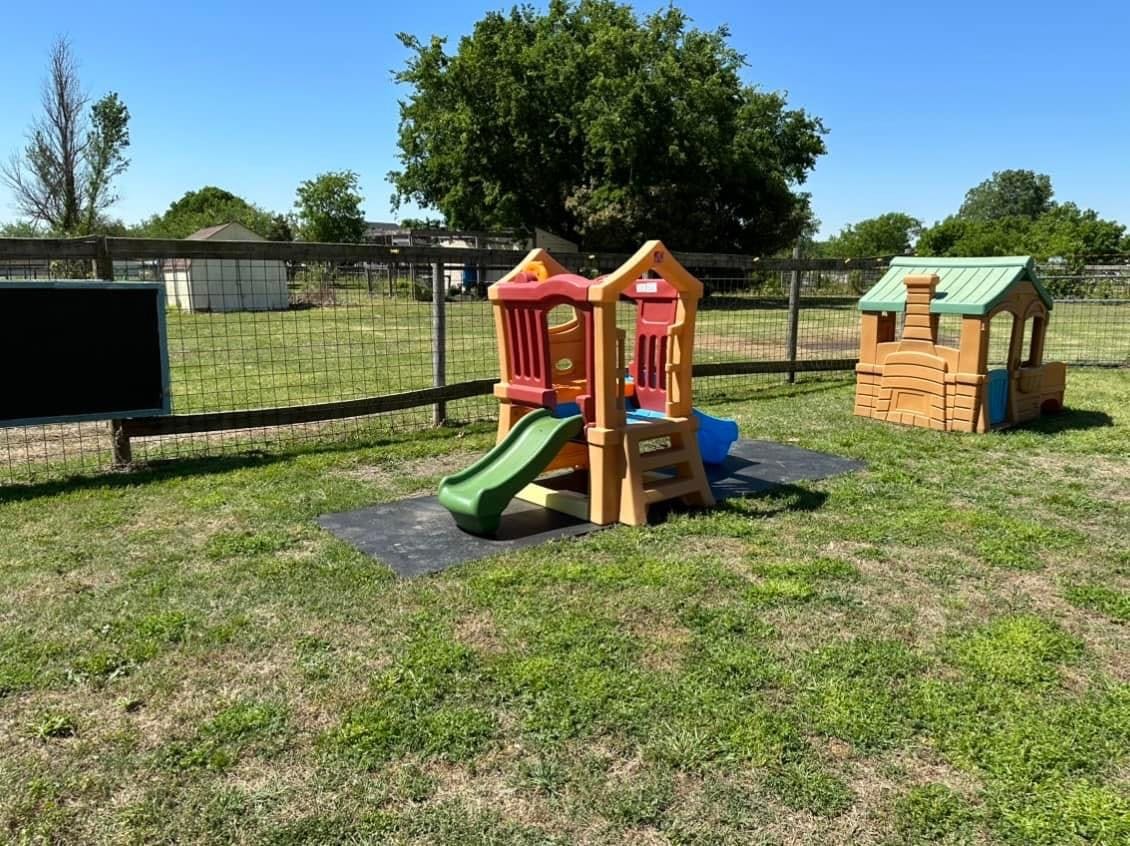 Outdoor playground with a slide and a small playhouse