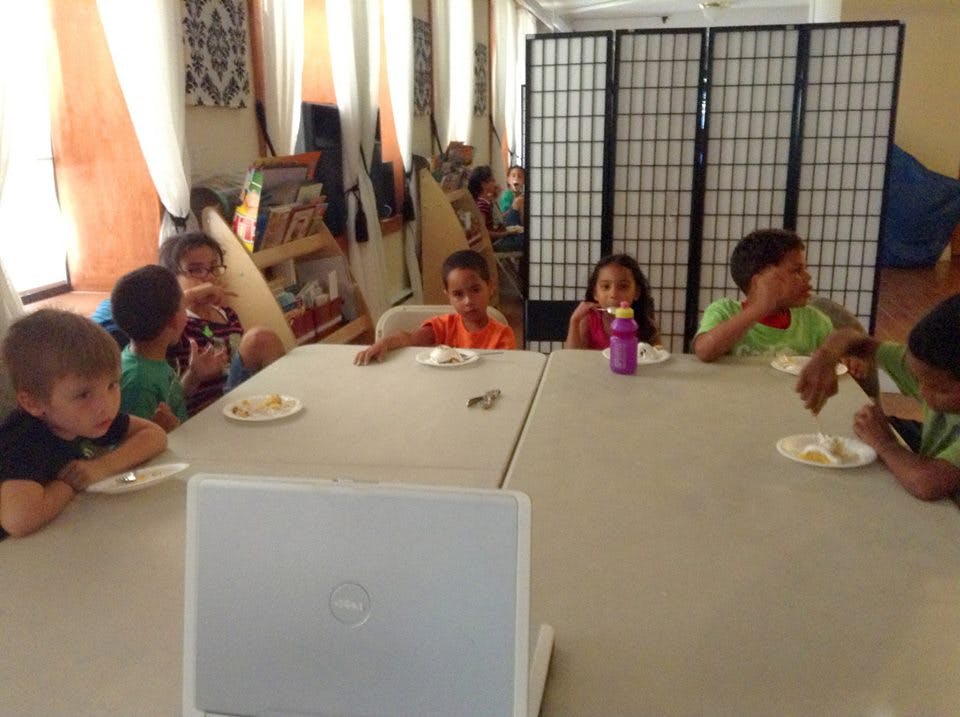Children sitting at tables with plates