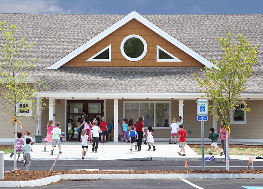 Children and adults entering and exiting a building