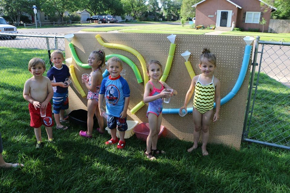 Children standing in front of a water play wall