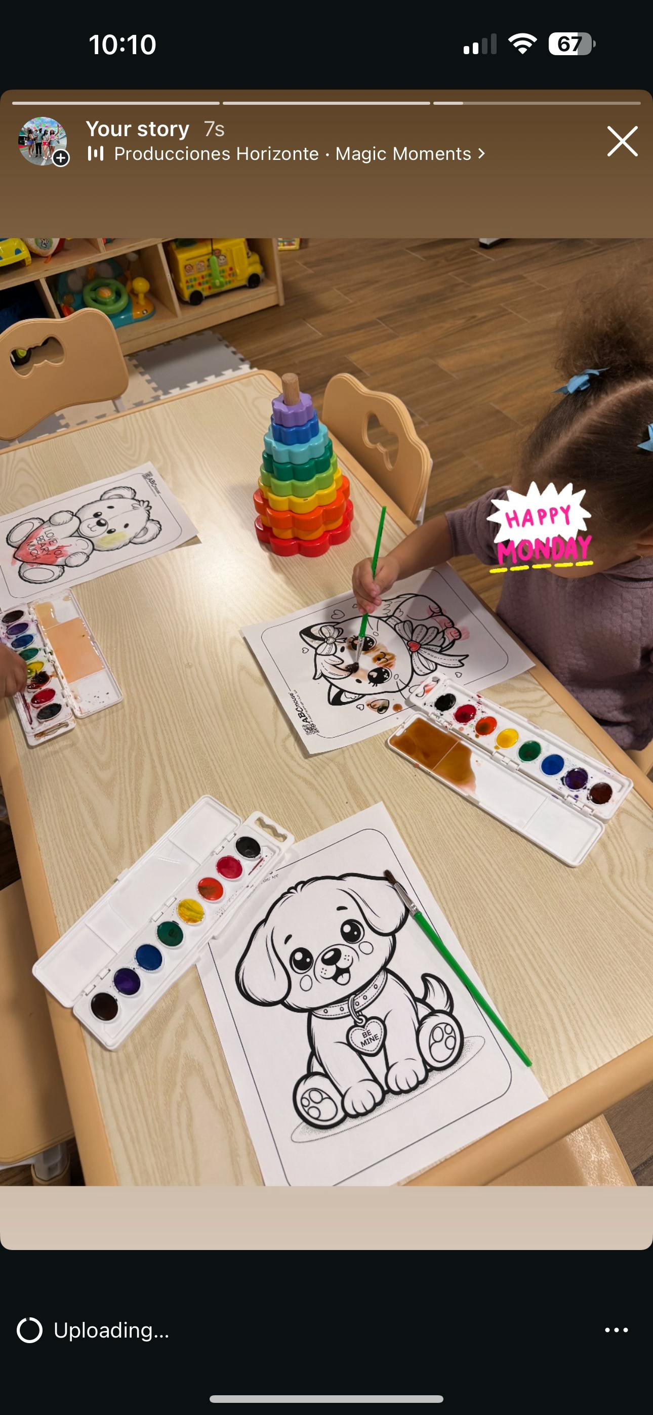 Child painting a coloring page at a table with watercolors
