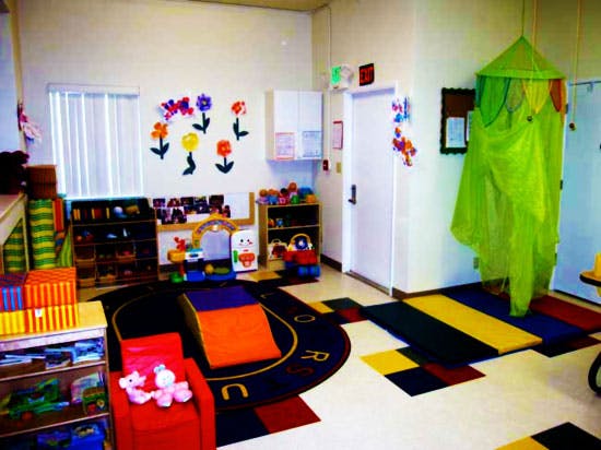Playroom with colorful rug, toys, and wall decorations