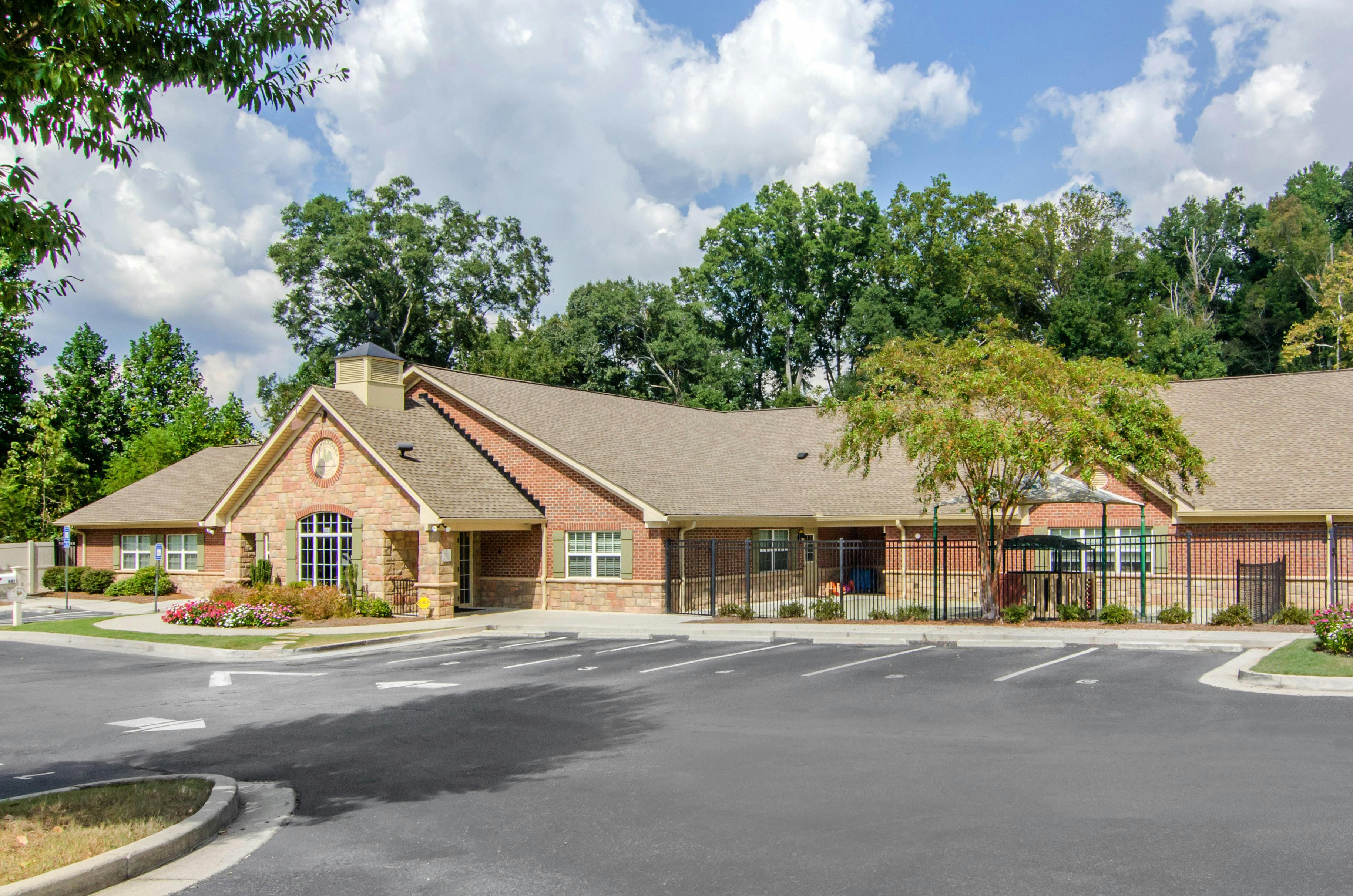 Brick building with stone accents and a parking lot in front