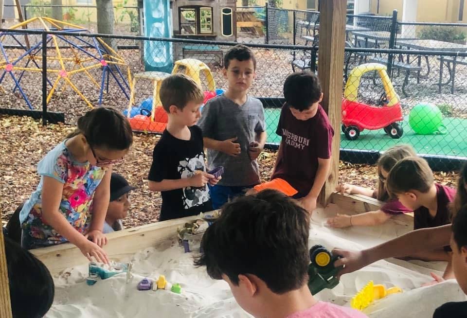 Children playing in a sandbox outdoors
