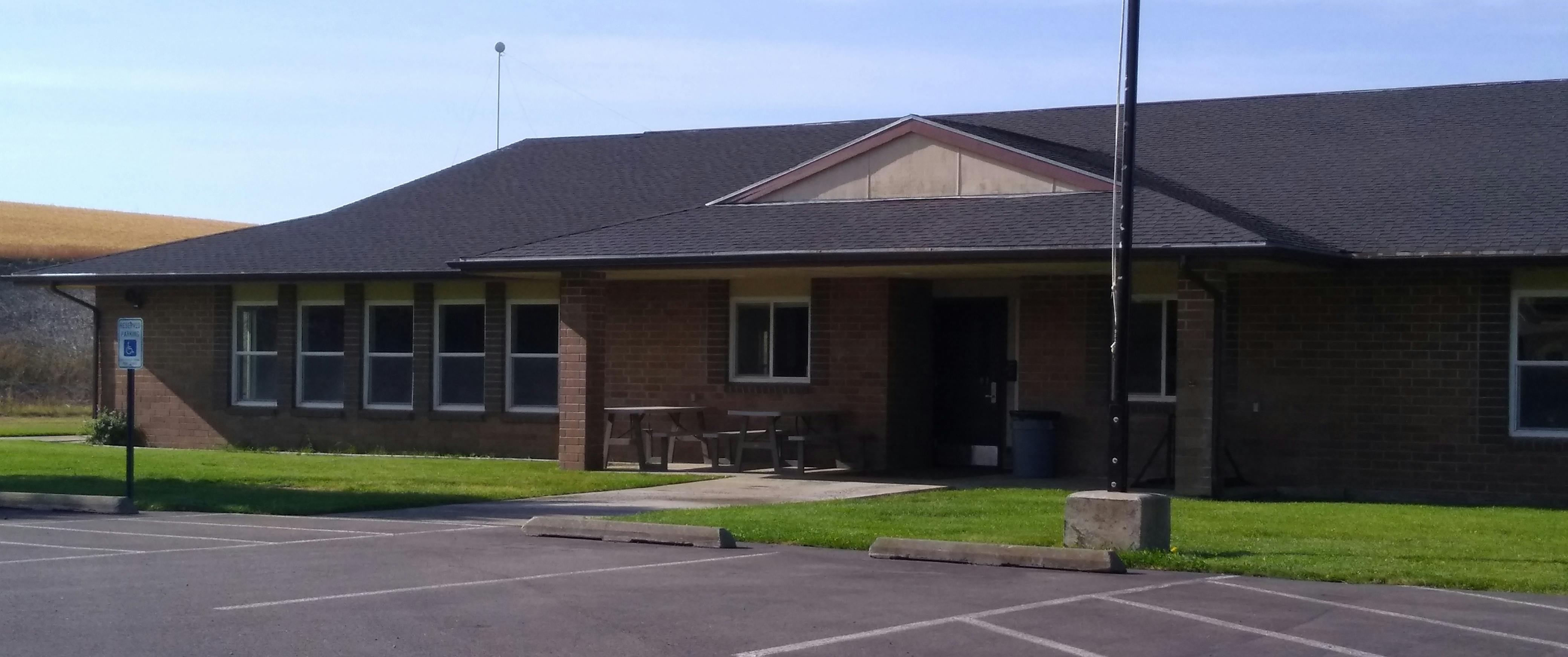Single-story building with a dark roof and multiple windows