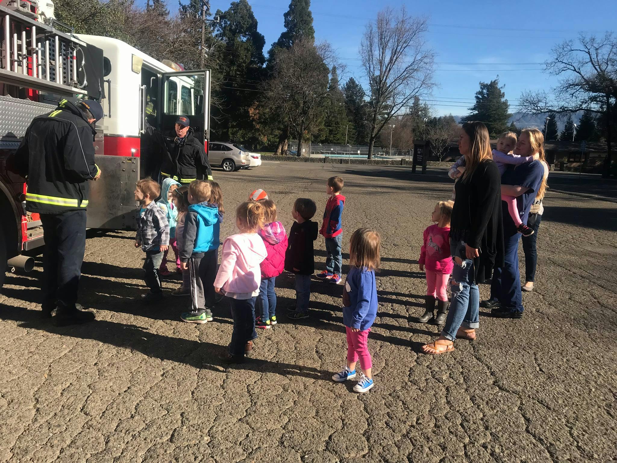 People and children gathered around a fire truck