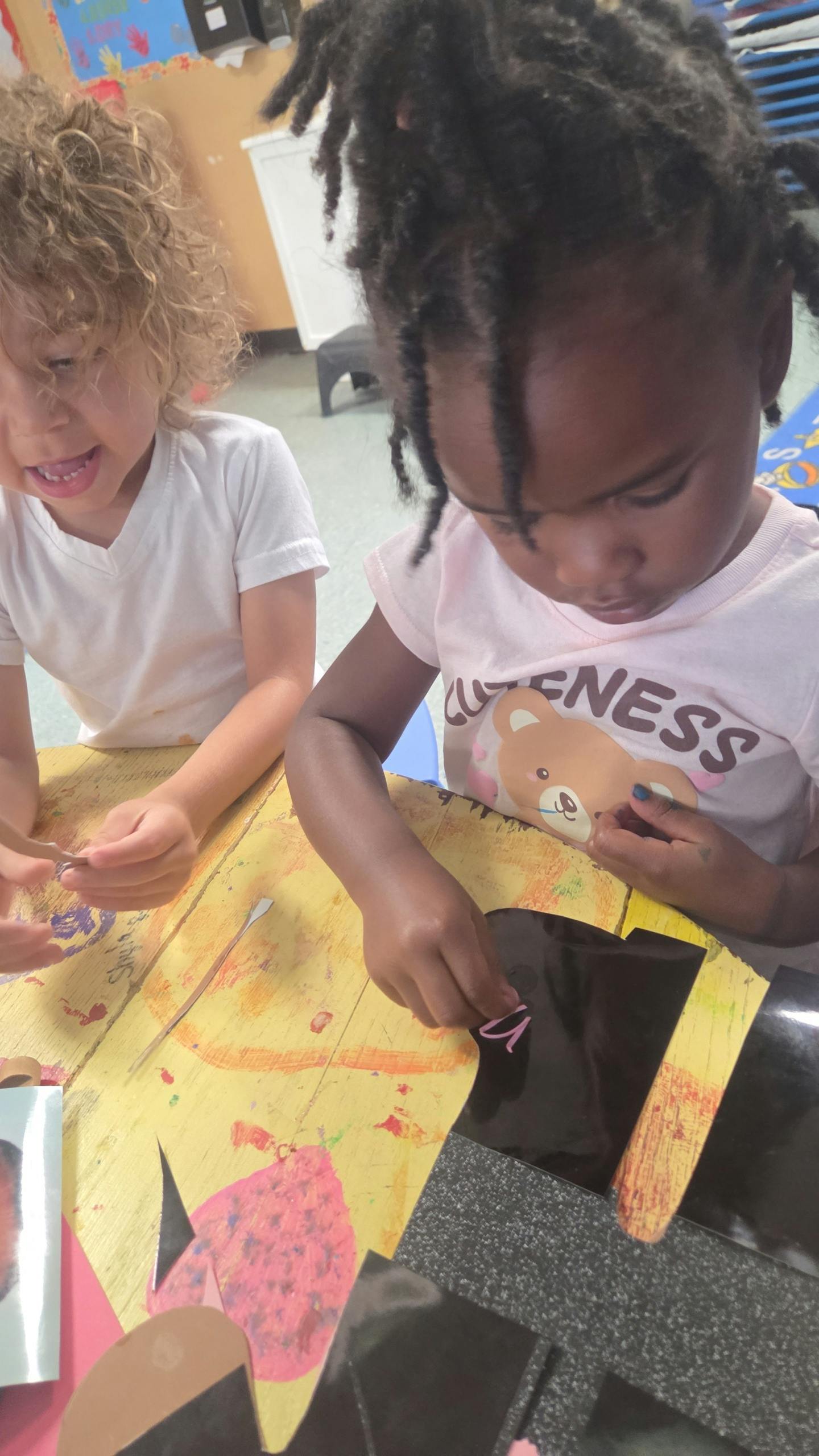 Two children at a table doing crafts