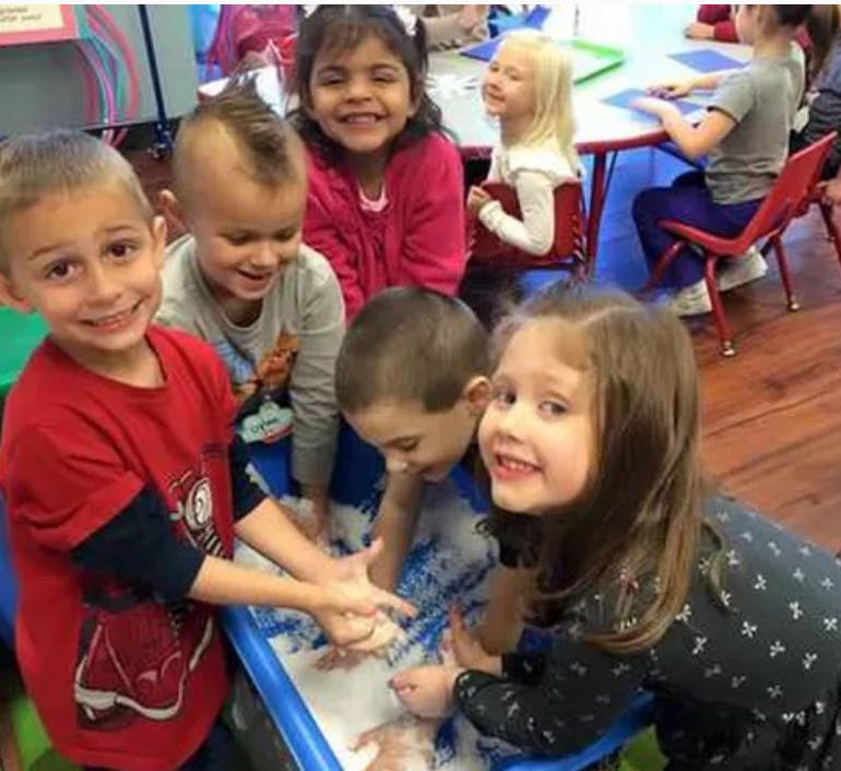 Children playing with a sensory bin in a classroom
