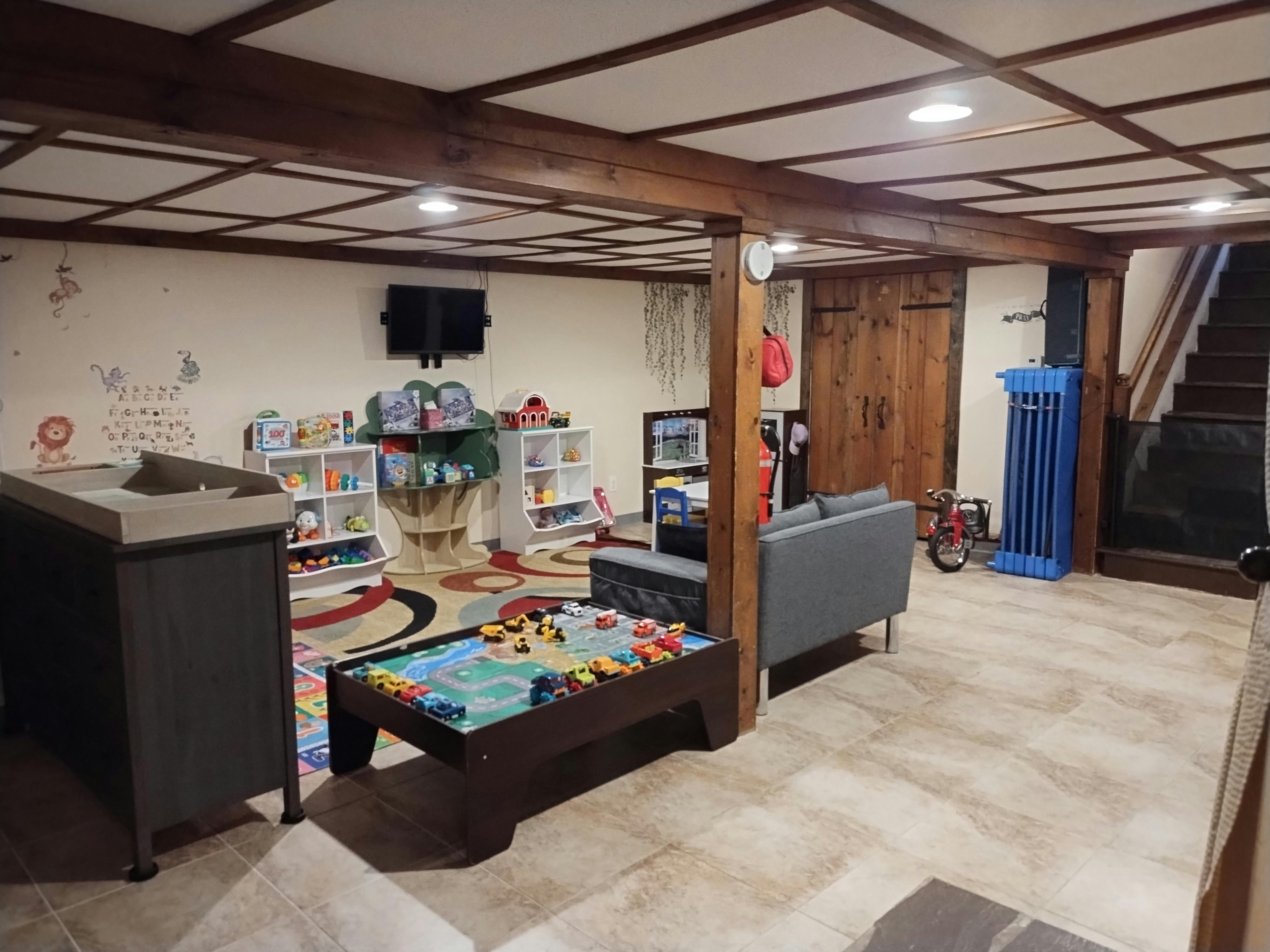 Playroom with a play table, shelves, and seating