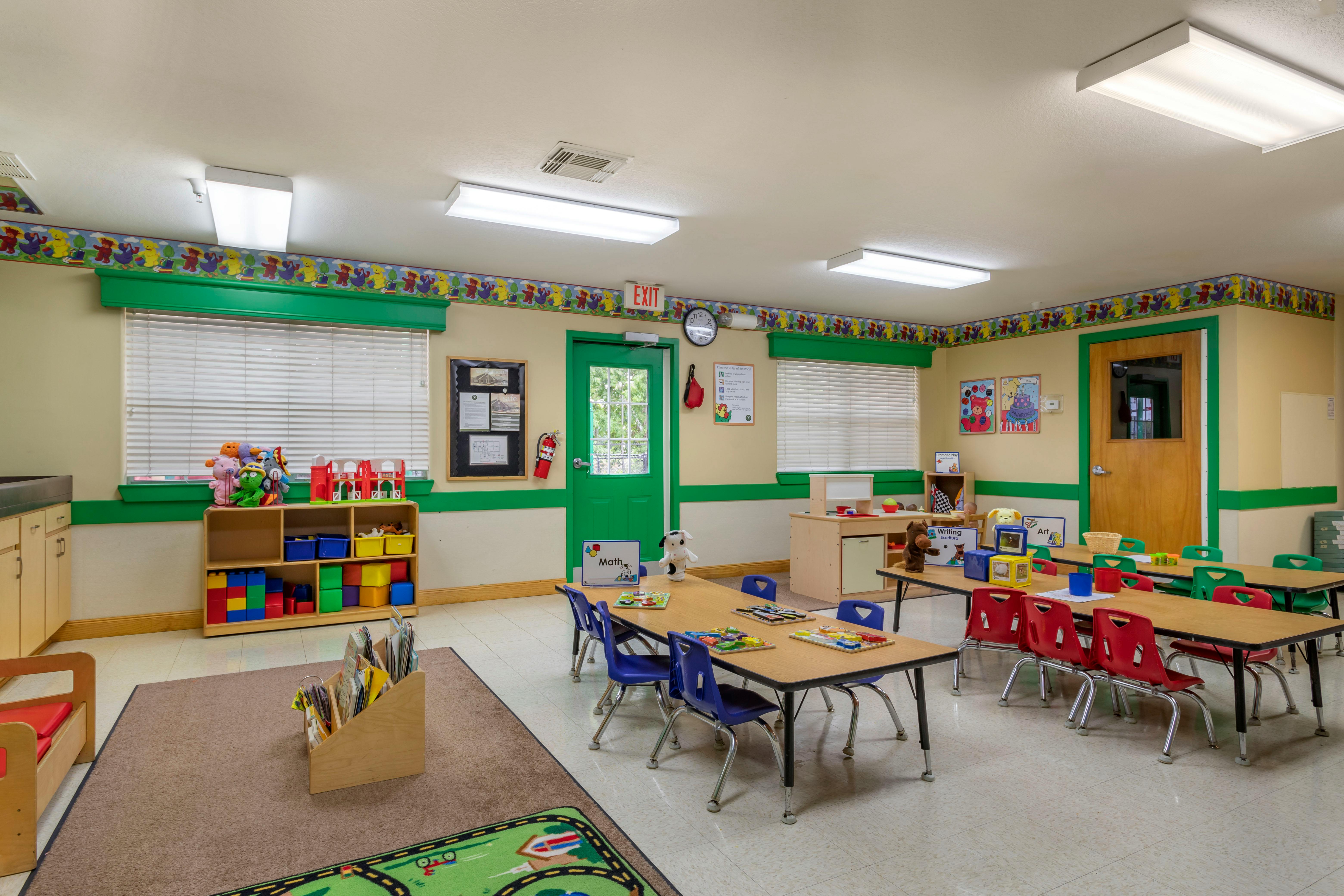 A colorful classroom for children with several tables and chairs