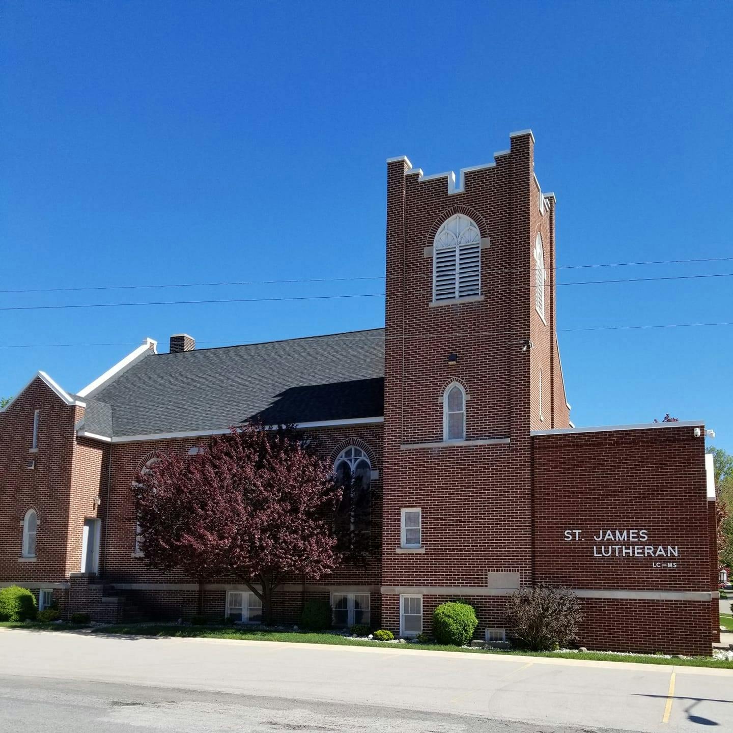 Brick church with a tall tower and a sign that reads "St James Lutheran"