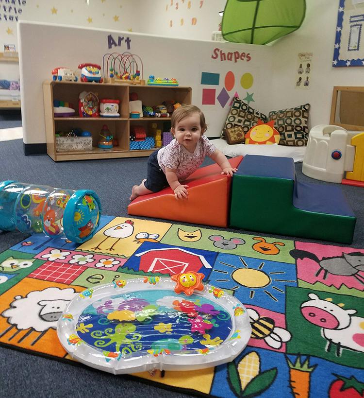Child crawling on soft play steps in a classroom