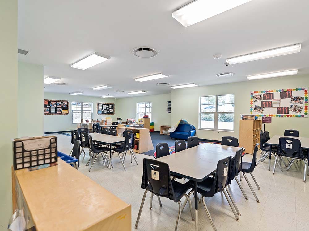 Empty classroom with small tables and chairs