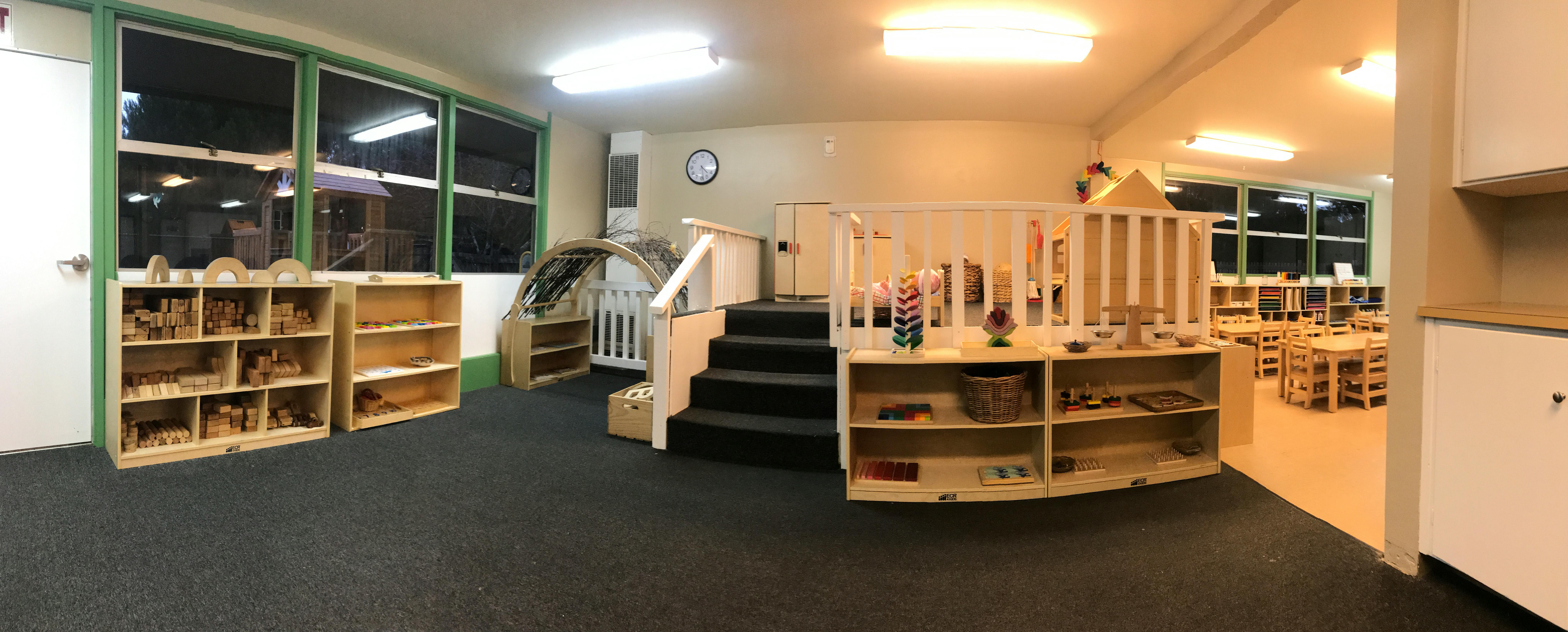 Empty classroom with shelves, stairs, and tables