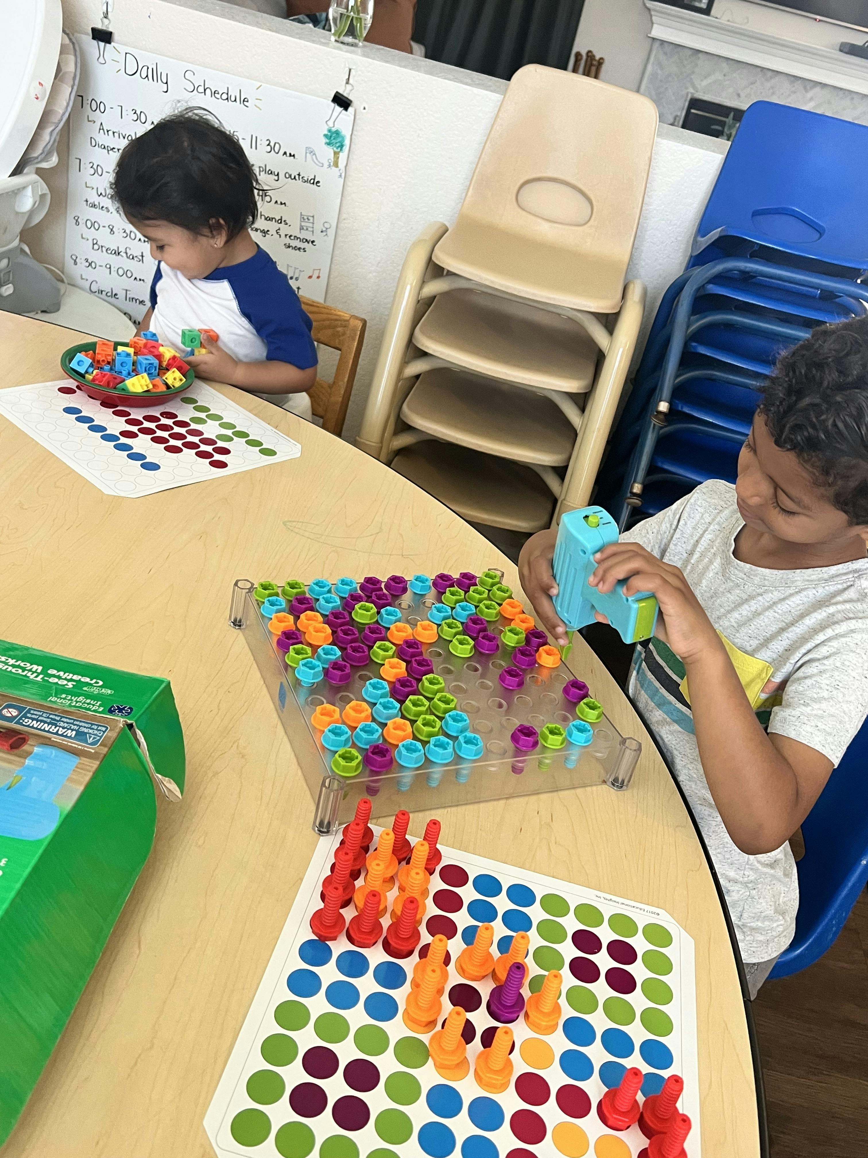 Two children playing with colorful learning toys at a table