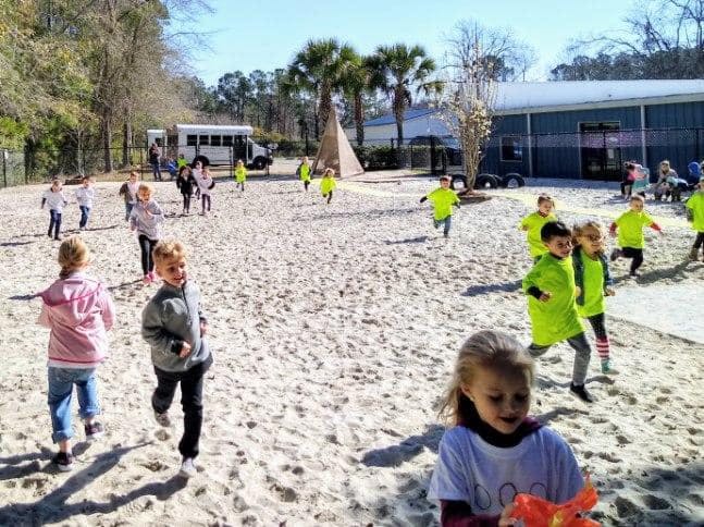 Children running on a sandy playground