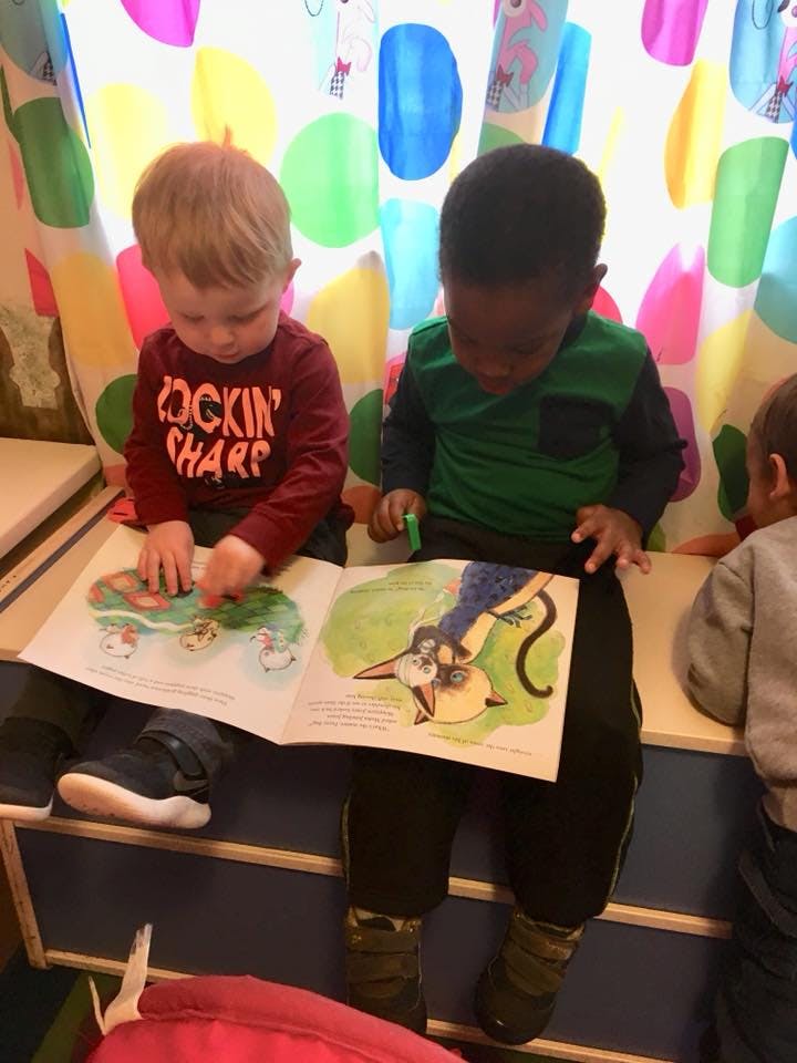 Two children looking at a book together