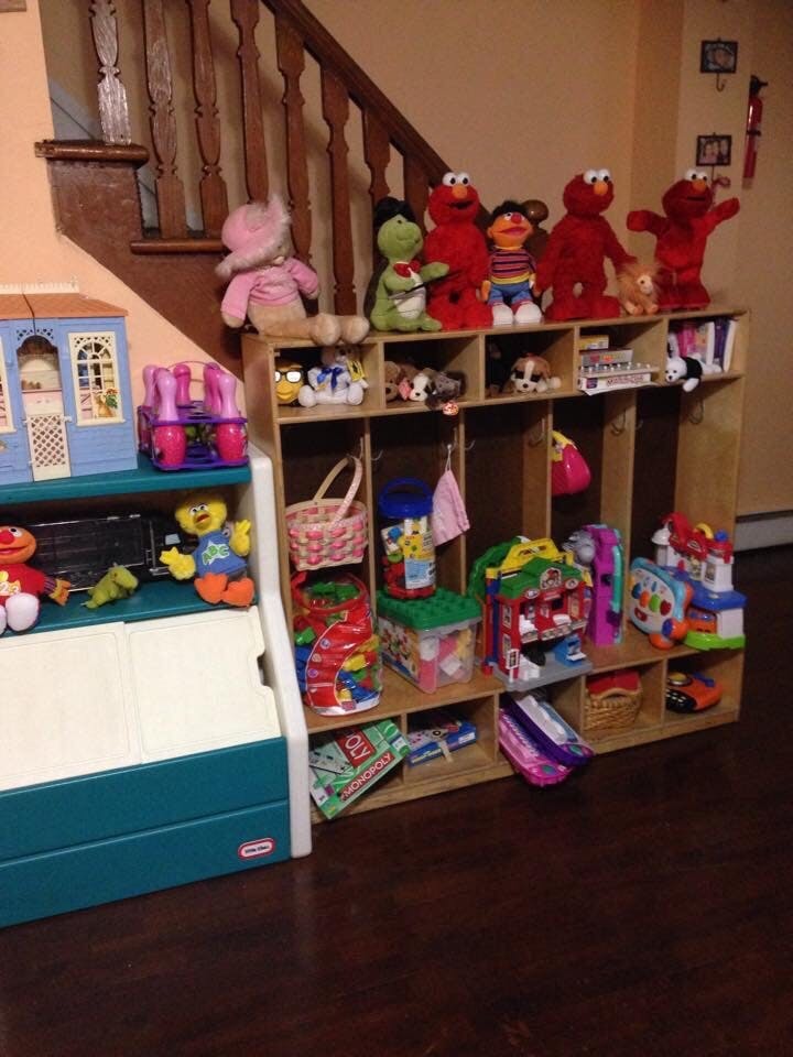 Stuffed animals and toys on a wooden shelf unit next to a staircase