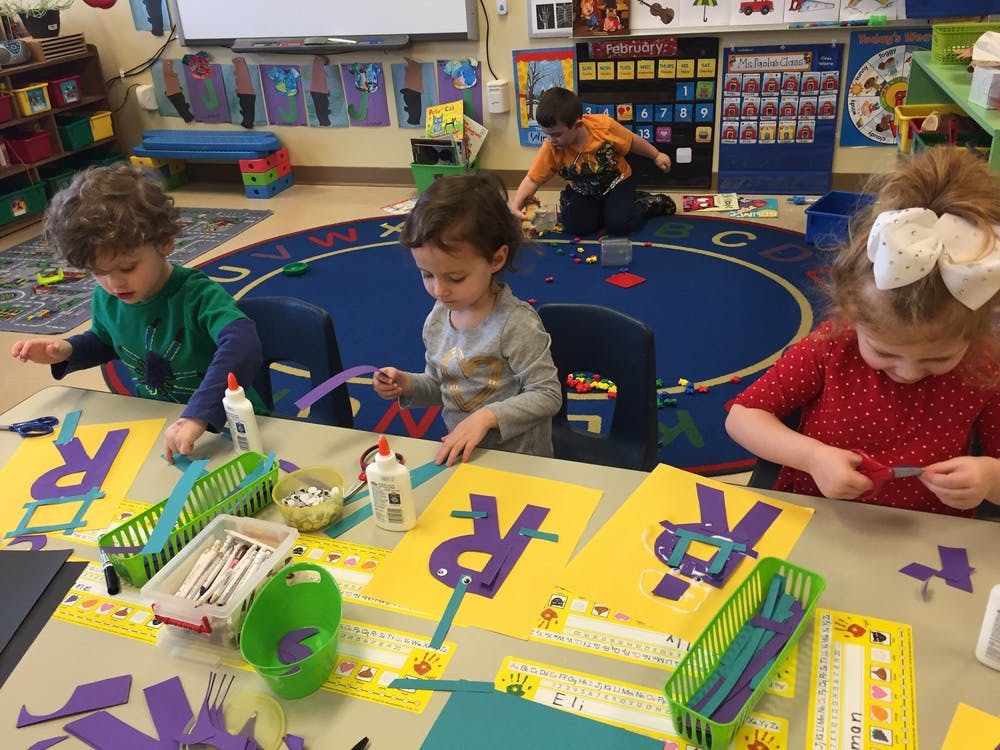 Children doing crafts at a table in a classroom