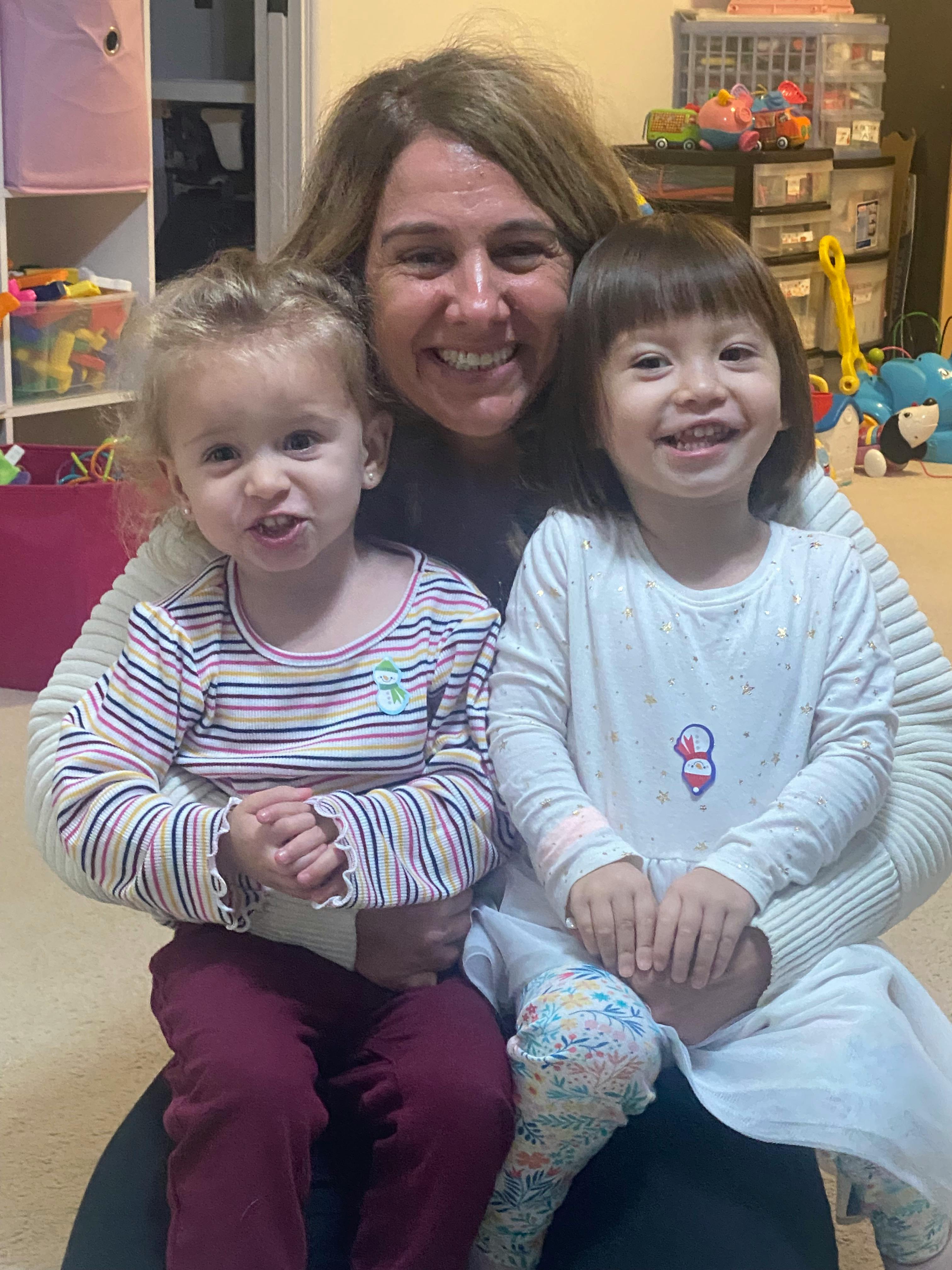 Adult holding two children in a room