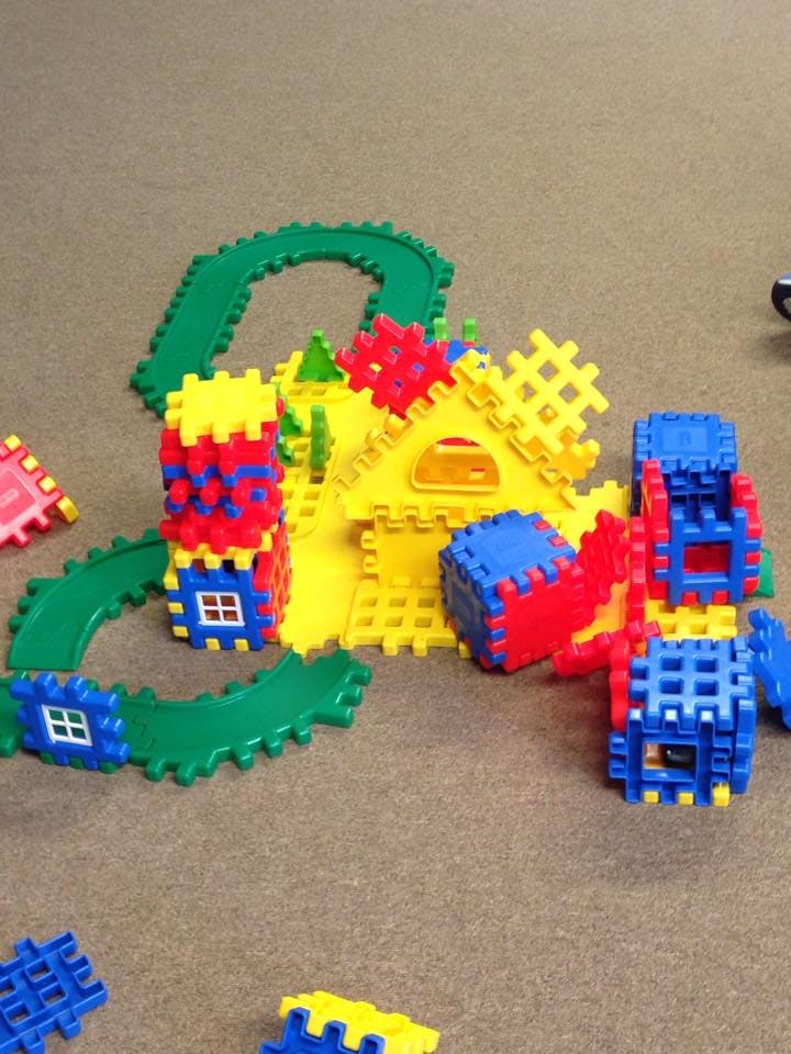 Colorful plastic building blocks assembled into structures and a track