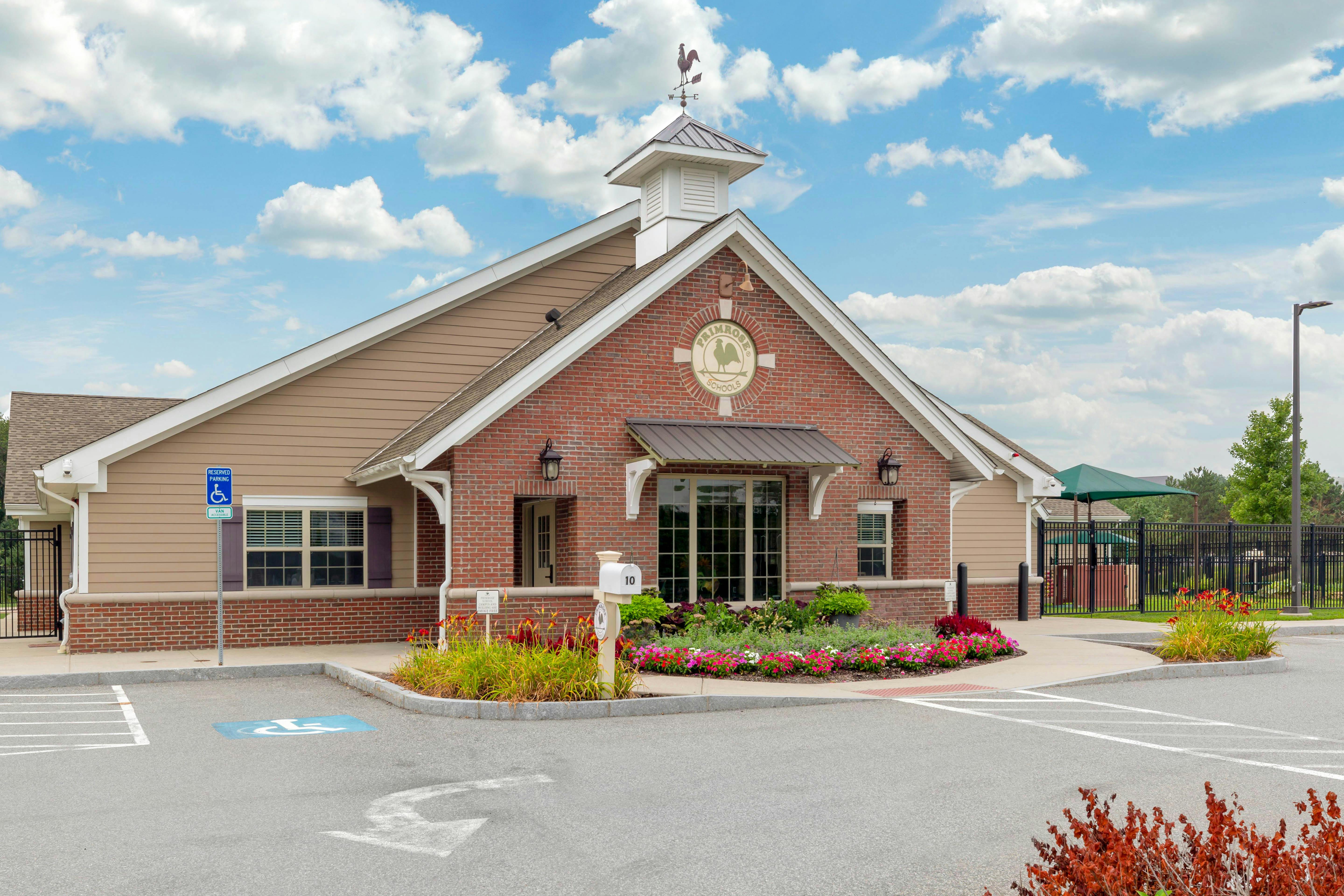Brick and tan building with a sign that reads "Primrose Schools" and a weather vane