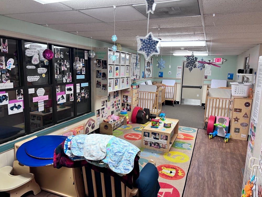 Cribs in a daycare classroom decorated with winter cutouts